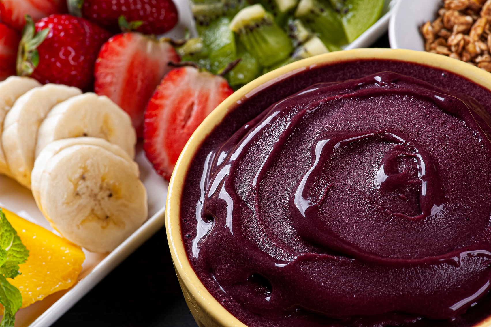 Brazilian frozen açaí in a bowl accompanied by tropical fruits. Fruit of the Amazon